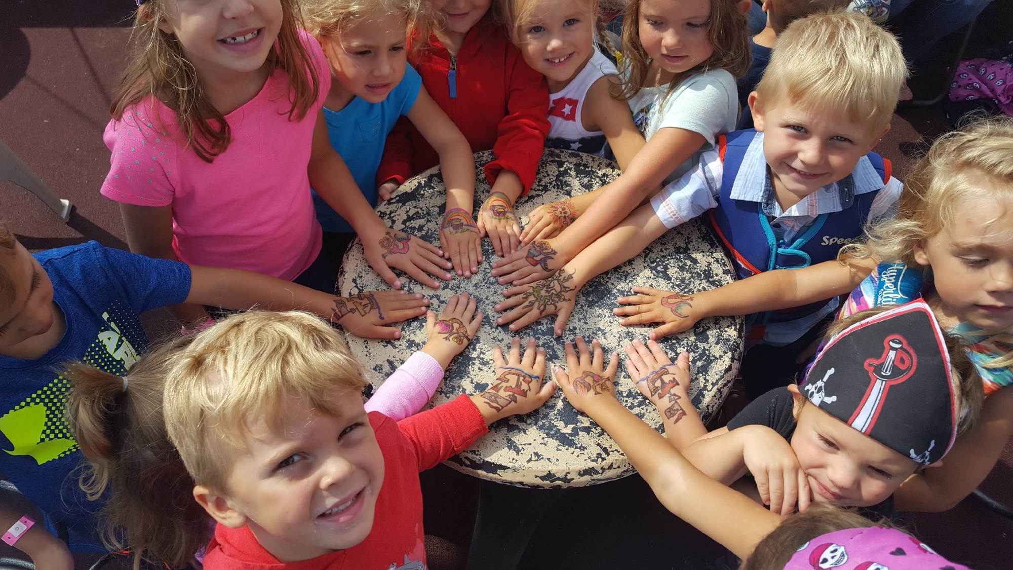a group of young children sitting next to a little girl
