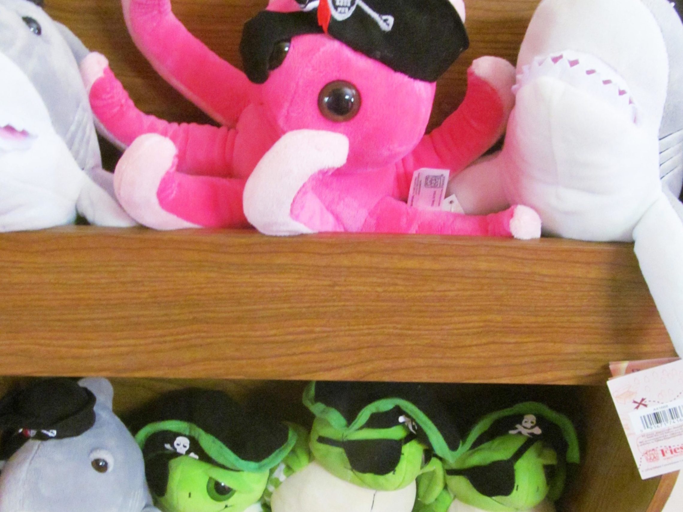 a group of stuffed animals sitting on top of a wooden table